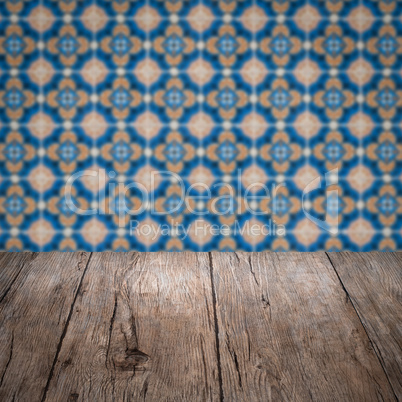 Wood table top and blur vintage ceramic tile pattern wall