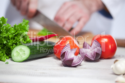 Chef cutting a green lettuce his kitchen