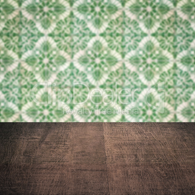 Wood table top and blur vintage ceramic tile pattern wall