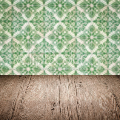 Wood table top and blur vintage ceramic tile pattern wall