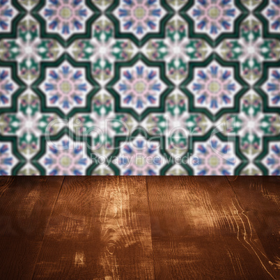 Wood table top and blur vintage ceramic tile pattern wall