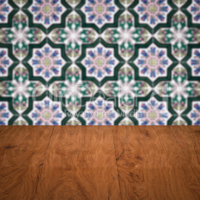 Wood table top and blur vintage ceramic tile pattern wall