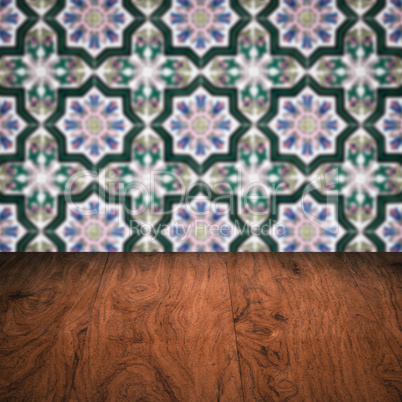 Wood table top and blur vintage ceramic tile pattern wall Wood table top and blur vintage ceramic tile pattern wall