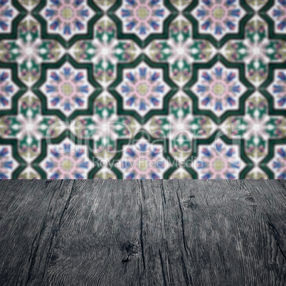 Wood table top and blur vintage ceramic tile pattern wall