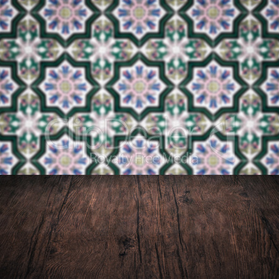 Wood table top and blur vintage ceramic tile pattern wall