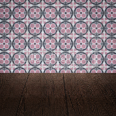 Wood table top and blur vintage ceramic tile pattern wall