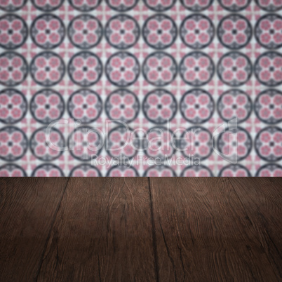 Wood table top and blur vintage ceramic tile pattern wall