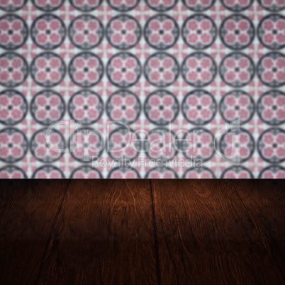 Wood table top and blur vintage ceramic tile pattern wall