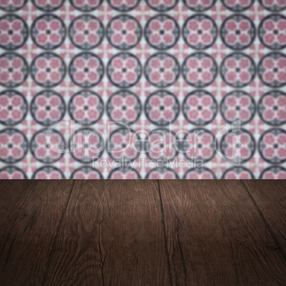 Wood table top and blur vintage ceramic tile pattern wall