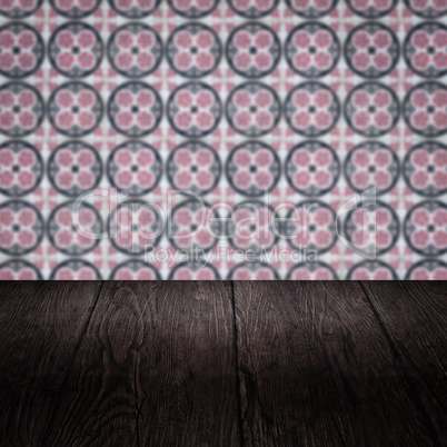 Wood table top and blur vintage ceramic tile pattern wall