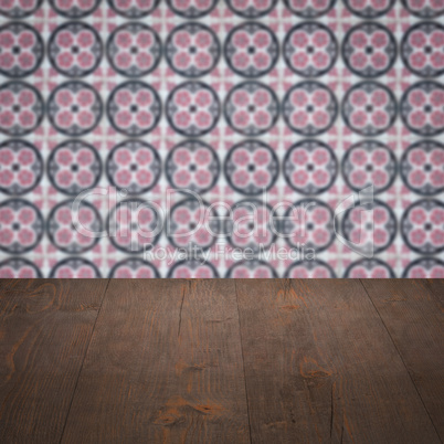 Wood table top and blur vintage ceramic tile pattern wall