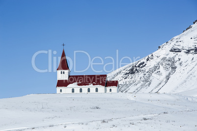 Church of Vik in wintertime with snowy mountains, Iceland