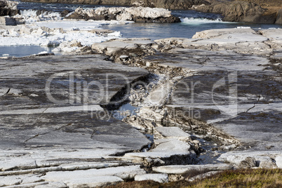 Glacial ice float away on a river bank, Iceland