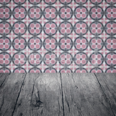 Wood table top and blur vintage ceramic tile pattern wall