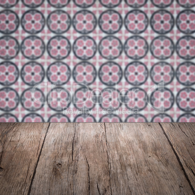 Wood table top and blur vintage ceramic tile pattern wall