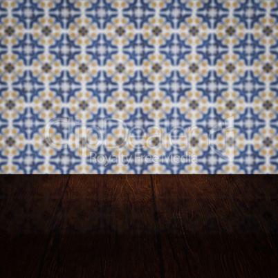 Wood table top and blur vintage ceramic tile pattern wall