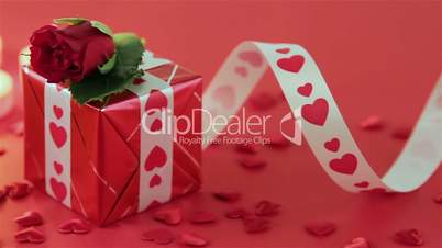 Red roses and gift box on red background