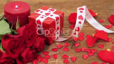 Red roses and gift box on wooden background