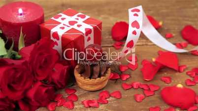 Chocolate cupcake with roses and gift on wood