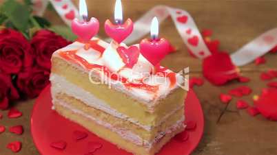 Decorated cake with candles and roses on wood