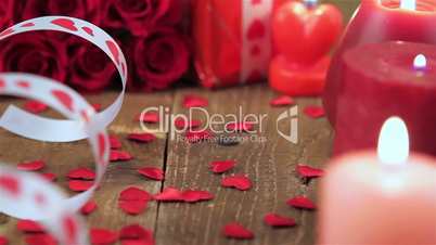 Red roses and gift box on wooden background