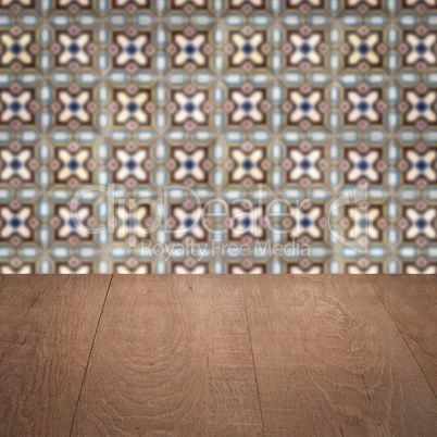 Wood table top and blur vintage ceramic tile pattern wall