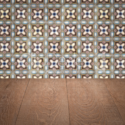 Wood table top and blur vintage ceramic tile pattern wall