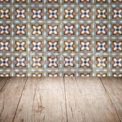 Wood table top and blur vintage ceramic tile pattern wall