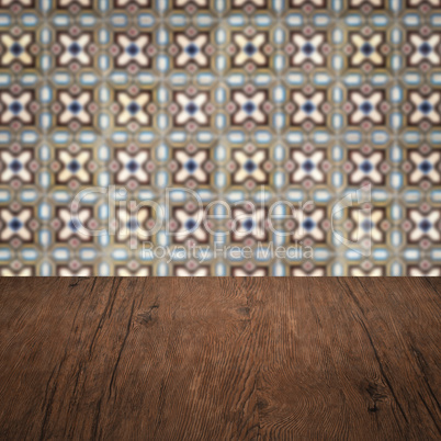 Wood table top and blur vintage ceramic tile pattern wall Wood table top and blur vintage ceramic tile pattern wall