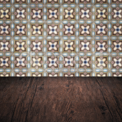 Wood table top and blur vintage ceramic tile pattern wall