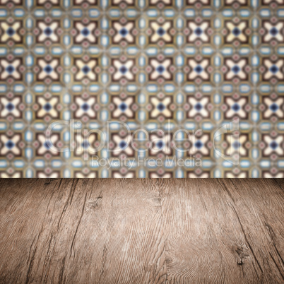 Wood table top and blur vintage ceramic tile pattern wall Wood table top and blur vintage ceramic tile pattern wall
