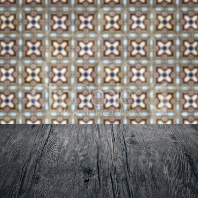 Wood table top and blur vintage ceramic tile pattern wall Wood table top and blur vintage ceramic tile pattern wall