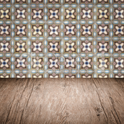 Wood table top and blur vintage ceramic tile pattern wall