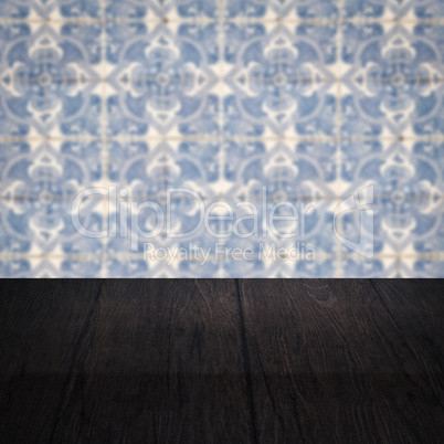 Wood table top and blur vintage ceramic tile pattern wall