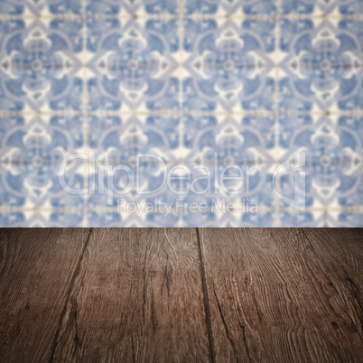 Wood table top and blur vintage ceramic tile pattern wall