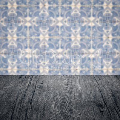 Wood table top and blur vintage ceramic tile pattern wall