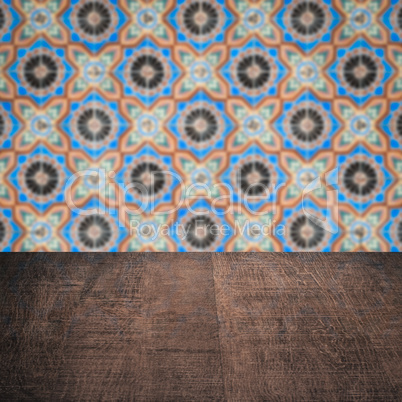 Wood table top and blur vintage ceramic tile pattern wall Wood table top and blur vintage ceramic tile pattern wall