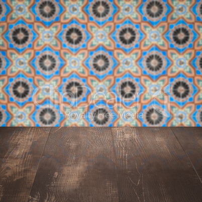 Wood table top and blur vintage ceramic tile pattern wall Wood table top and blur vintage ceramic tile pattern wall