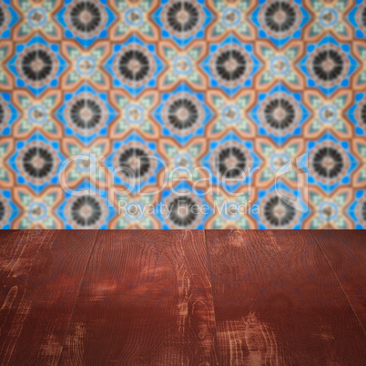 Wood table top and blur vintage ceramic tile pattern wall