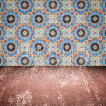 Wood table top and blur vintage ceramic tile pattern wall