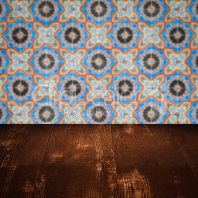 Wood table top and blur vintage ceramic tile pattern wall