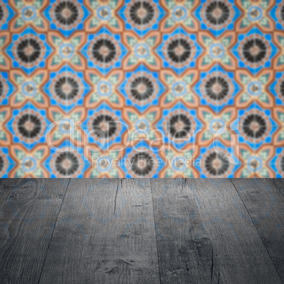 Wood table top and blur vintage ceramic tile pattern wall