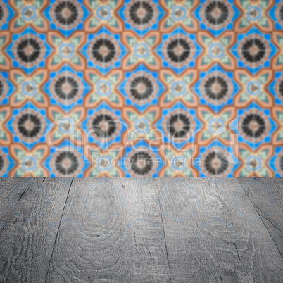 Wood table top and blur vintage ceramic tile pattern wall Wood table top and blur vintage ceramic tile pattern wall