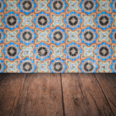 Wood table top and blur vintage ceramic tile pattern wall