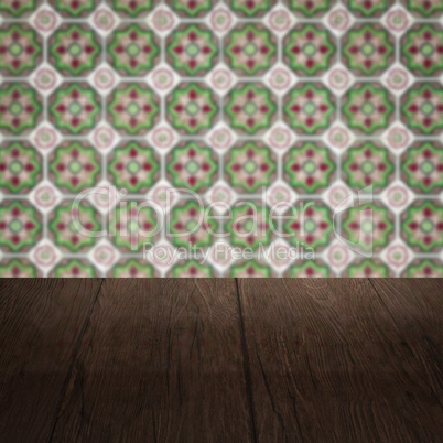 Wood table top and blur vintage ceramic tile pattern wall