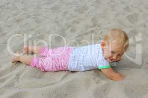 baby plays about on the white sand