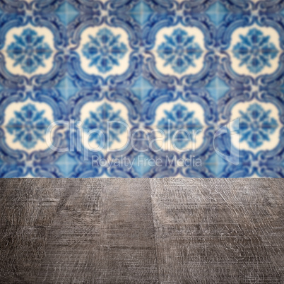 Wood table top and blur vintage ceramic tile pattern wall