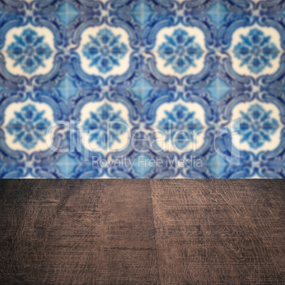 Wood table top and blur vintage ceramic tile pattern wall