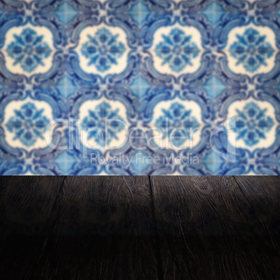 Wood table top and blur vintage ceramic tile pattern wall