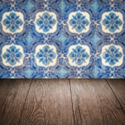 Wood table top and blur vintage ceramic tile pattern wall